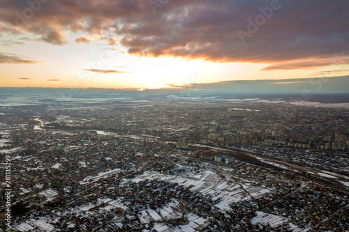 Top view of city suburbs or small town nice houses on winter morning on cloudy sky background. Aerial drone photography concept.