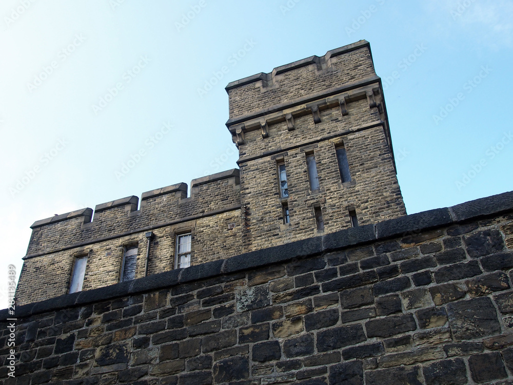 an abandoned victorian british institutional building typical of 19th century military and prison architecture surrounded by high stone wall formerly the wellesley barracks on gibbet lane in halifax