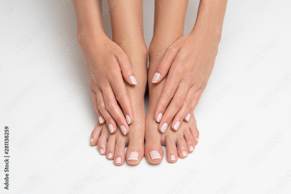 Naklejka premium Perfectly done manicure and pedicure on white background.
