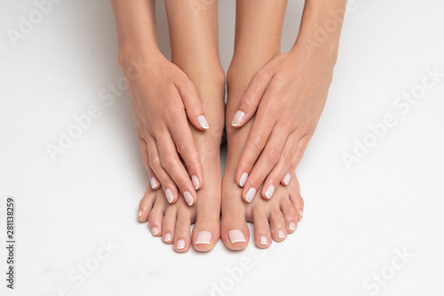 Perfectly done manicure and pedicure on white background.