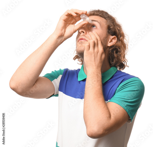 Young man with eye drops on...