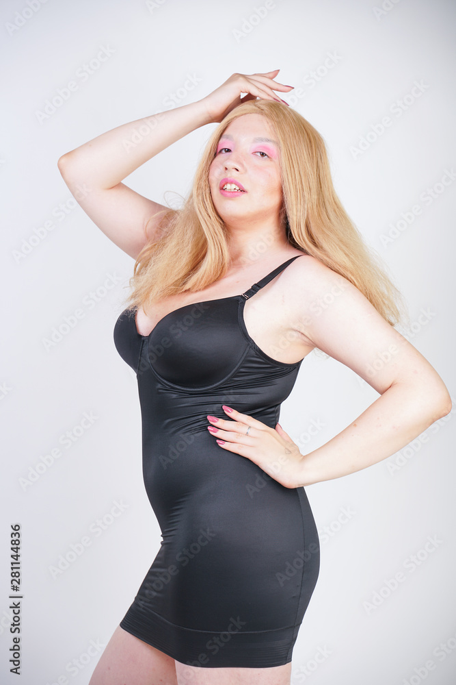 hot chubby blonde asian adult girl in sexy tight little black dress  lingerie on white studio background standing alone Stock Photo | Adobe Stock