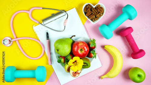 Healthy lifestyle prescription for good health concept flatlay with stethoscope, healthy food, and exercise equipment on modern pastel background.
