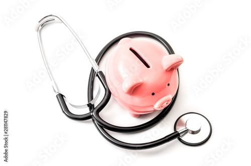 Healthcare cost and the high price of quality health care insurance concept theme with a stethoscope and a pink piggy bank isolated on white background photo