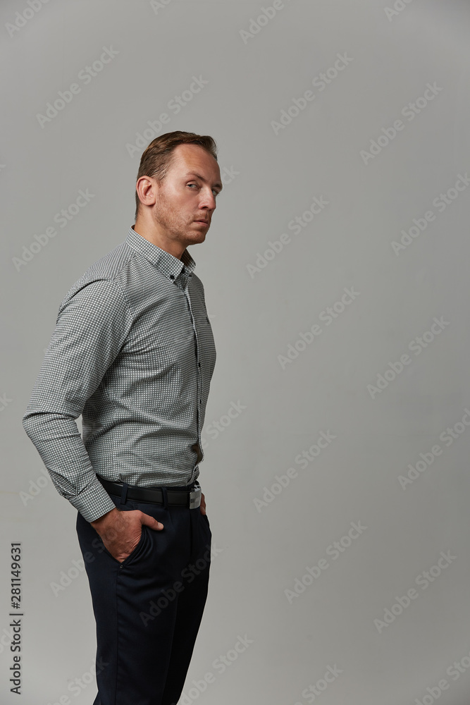 A man in a shirt shows with his hands on your text or your advertisement on a gray background. Concept banner for advertising, copy space, gray background, commercial design A man in a shirt shows with his hands on your text or your advertisement on a gray background. Concept banner for advertising, copy space, gray background, commercial design