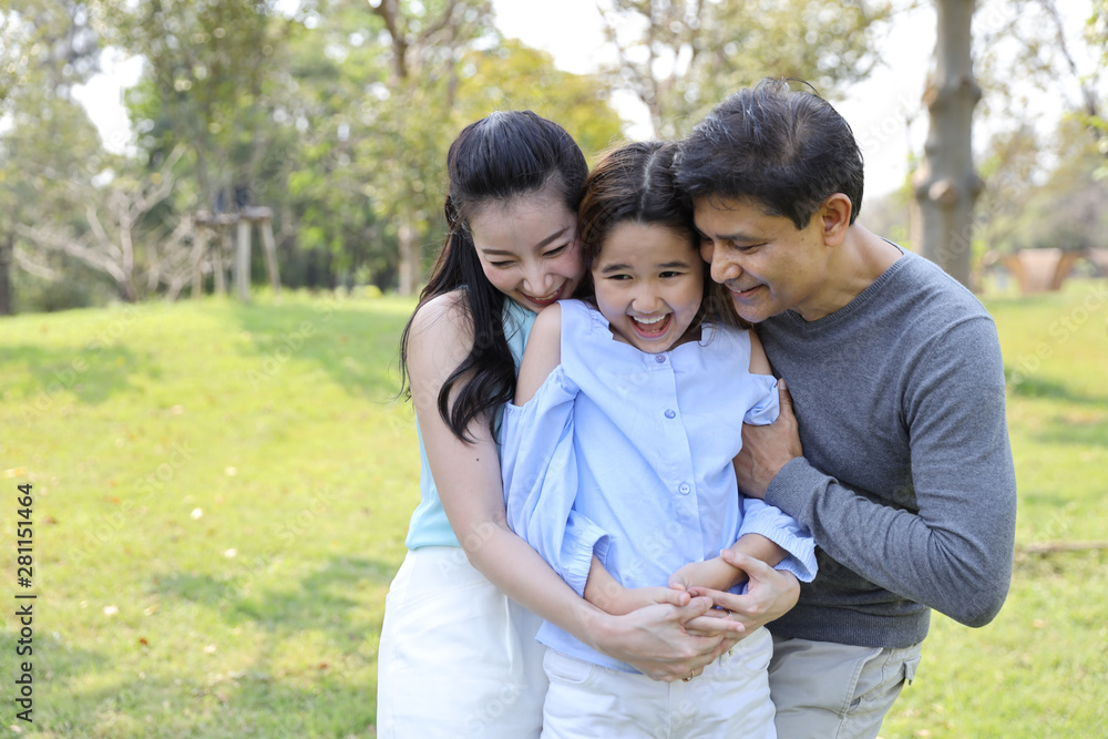 image of 3 happiness family, daughter and parents having a happy time in the park with smiling and laughing on sunny day during holiday vacation image of 3 happiness family, daughter and parents having a happy time in the park with smiling and laughing on sunny day during holiday vacation