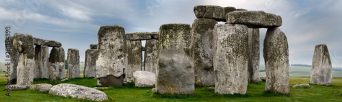 Panorama of Stonehenge prehistoric stone circle ruins amongst farm fields in Wiltshire England at dawn