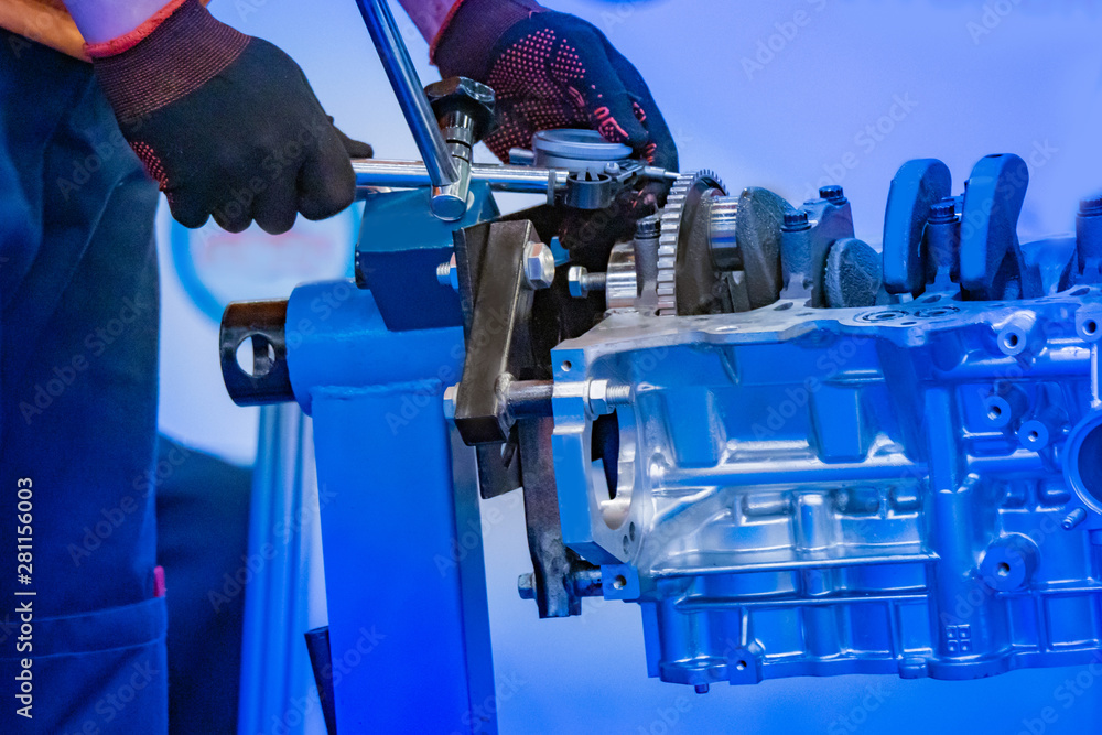Automotive engine. Motor car. The mechanic uses a tool with a pressure gauge. Locksmith repairs the engine. Engine service. Drive technology. Motor production. Auto industry. Engineering. Automotive engine. Motor car. The mechanic uses a tool with a pressure gauge. Locksmith repairs the engine. Engine service. Drive technology. Motor production. Auto industry. Engineering.