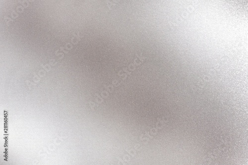 Glowing silver metallic panel with scratched surface, abstract texture background
