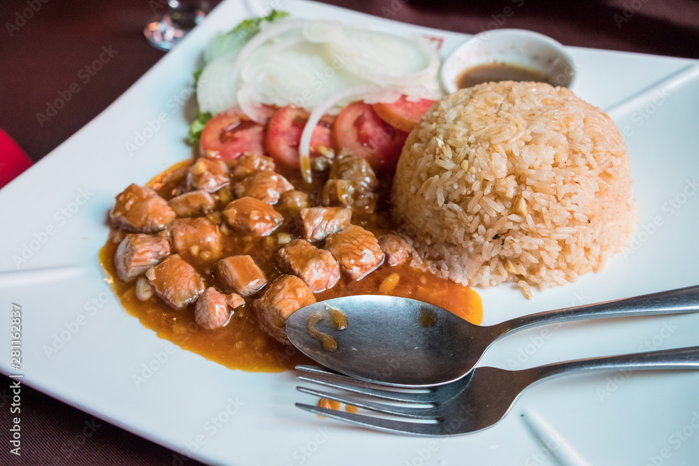 Fototapeta premium Shot of Beef Lok Lak one of the most popular Cambodia food served on dish. Lok Lak is cooked by stir-fried beef with oyster sauce, ground black pepper and garlic mixed together in high heat.