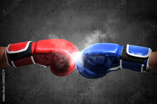 Hands of two men with blue and red boxing gloves bumped their fists © Leo Lintang