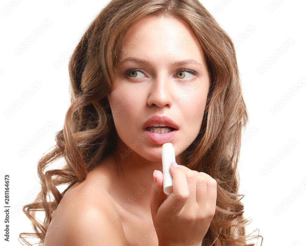 Beautiful young woman applying lipstick against white background Beautiful young woman applying lipstick against white background