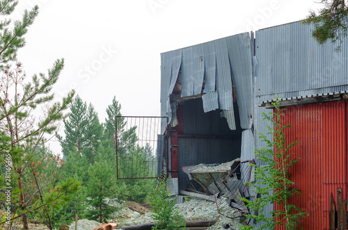 The hole in the metal wall of the hangar of the factory because of the body sticking out of the truck at the factory in Northern Yakutia. photo