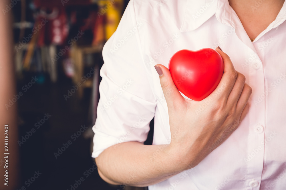 woman hold red heart and wearing white shirt woman hold red heart and wearing white shirt