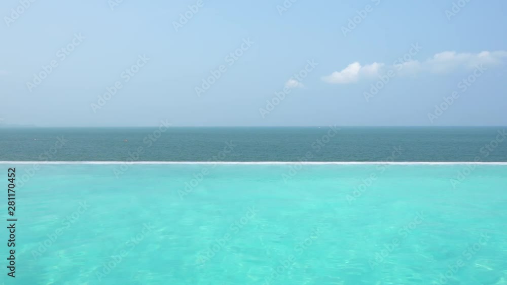 View of the tropical blue ocean from an infinity pool at a resort View of the tropical blue ocean from an infinity pool at a resort