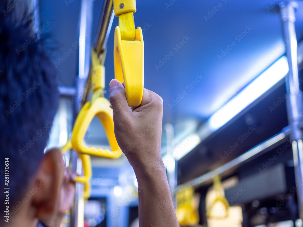 Close-up hand holding yellow handle in the bus. Close-up hand holding yellow handle in the bus.