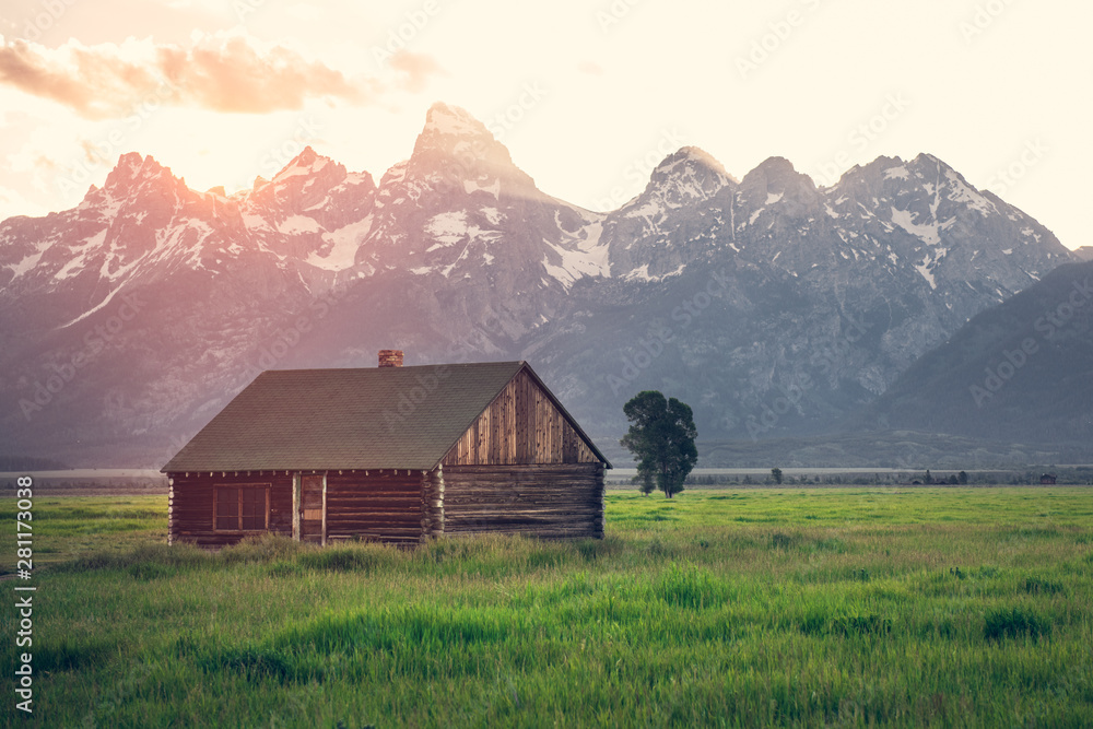 Old wooden house in mountains at summer sunset time