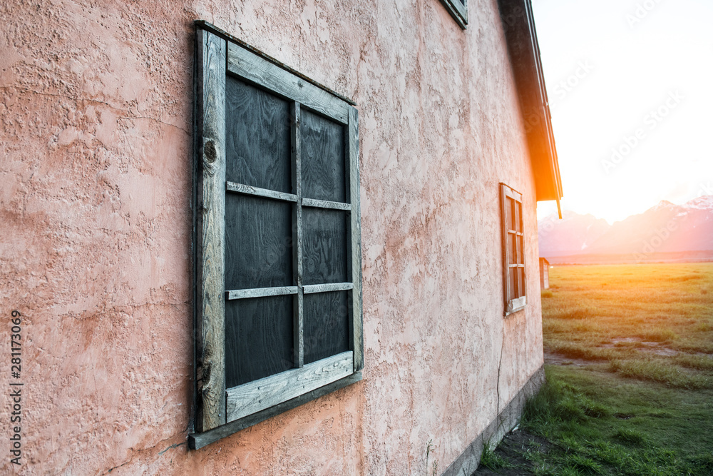 Old rusty wooden frame on stone painted pink wall on mountain house at sunset time Old rusty wooden frame on stone painted pink wall on mountain house at sunset time
