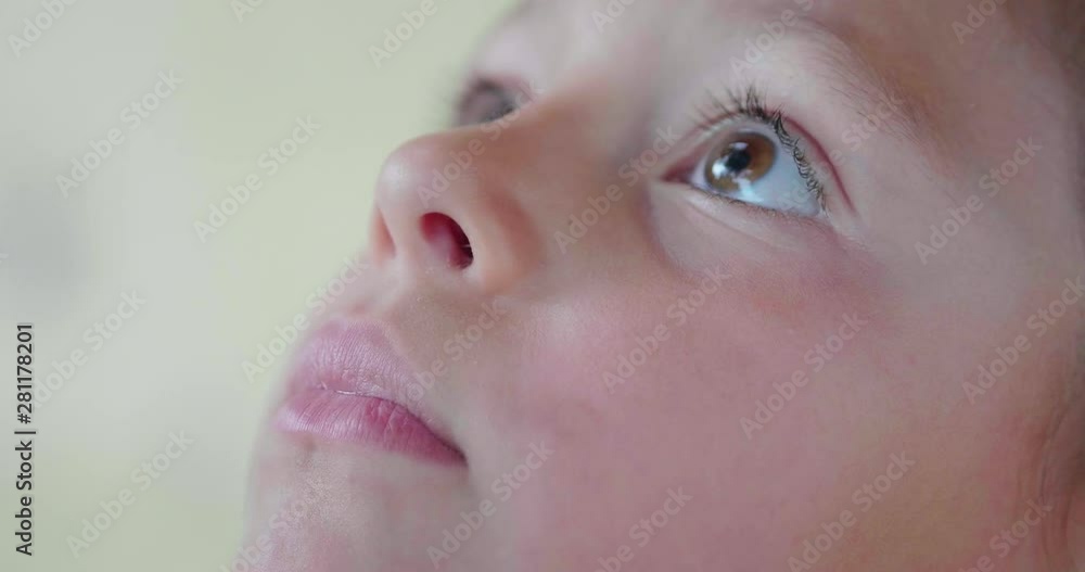 Authentic extra close up shot of cute serious little girl is looking up outside her house in the morning. Authentic extra close up shot of cute serious little girl is looking up outside her house in the morning.