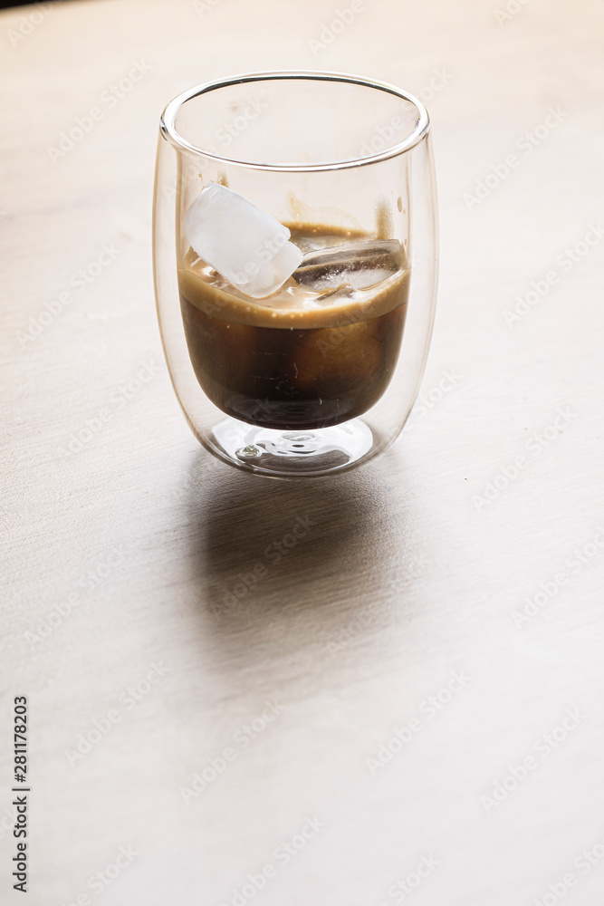 Espresso coffee with heart shaped ice rocks on a wooden background
