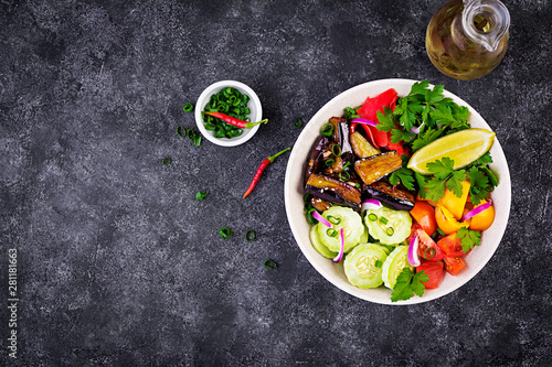 Salad fresh raw vegetables - armenian cucumber, tomatoes, paprika, parsley, red onion and stewed eggplant. Vegan buddha bowl. Top view