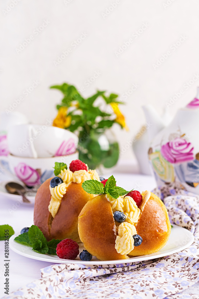 Rum baba decorated with whipped cream and fresh raspberry, blueberry. Savarin with rum, cream and berries. Italian cuisine Rum baba decorated with whipped cream and fresh raspberry, blueberry. Savarin with rum, cream and berries. Italian cuisine