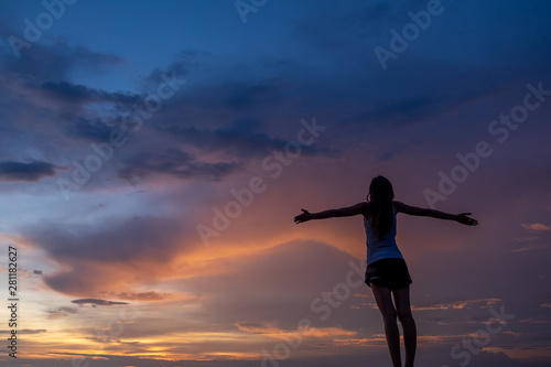 Fototapeta Naklejka Na Ścianę i Meble -  Silhouette of free woman enjoying freedom feeling happy at sunset. Serene relaxing woman in pure happiness