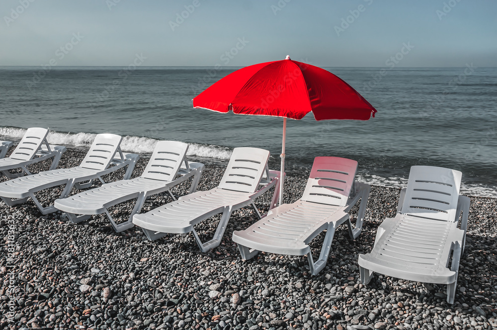 Sun umbrella and beach beds on the shingle beach Sun umbrella and beach beds on the shingle beach