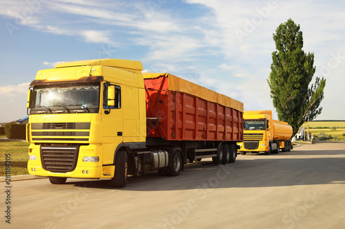 Modern bright trucks parked on country road