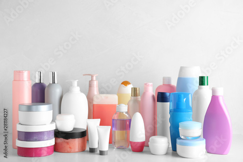 Different body care products on table against light background