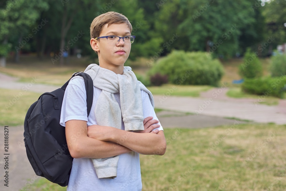 Portrait of teenager schoolboy in glasses with backpack