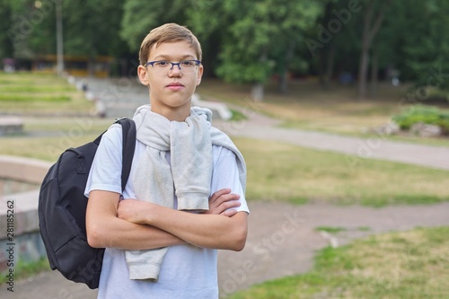 Outdoor portrait of teenager schoolboy with glasses backpack