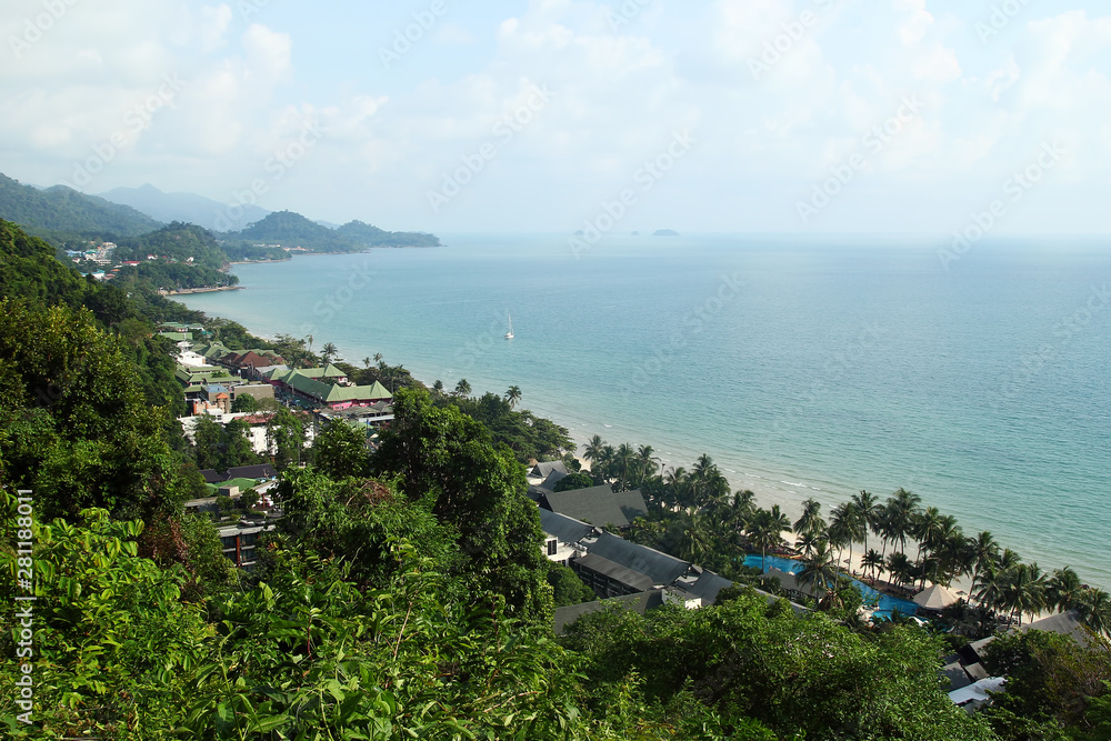 Aerial view of seashore in tropics with mountains, houses, hotels and clear blue sea. Koh Chang, Thailand.