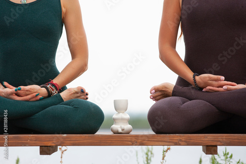 Two women doing yoga outdoors. yoga instructor shows poses. Close-up