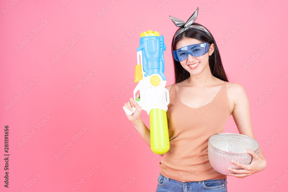 Pretty woman with squirt gun on pink background Pretty woman with squirt gun on pink background