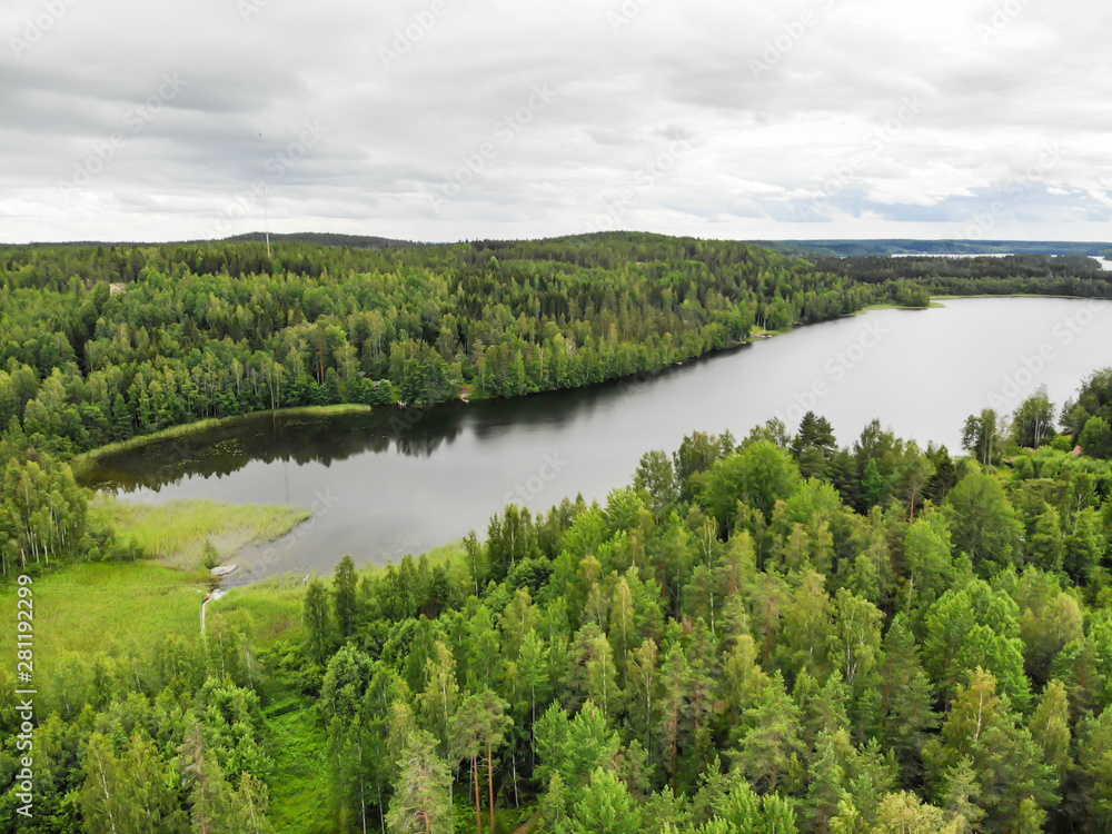 Aerial view of lake and green forest on a summer day in Finland. Drone photography