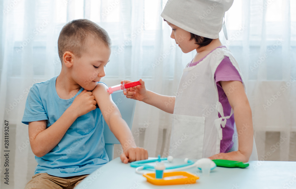 Children play in the hospital. The girl is dressed in a doctor 4 years ...