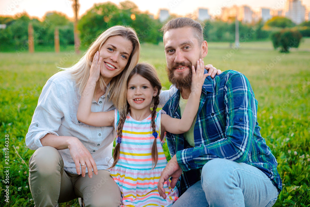 Happy young family spending time together outside in green nature.