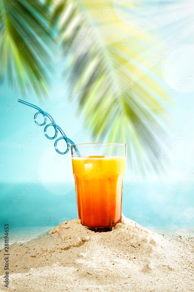 Table background with orange ice juice in a glass on a wooden table top with beautiful blue sky and ocean and palm tree view. Table background with orange ice juice in a glass on a wooden table top with beautiful blue sky and ocean and palm tree view.