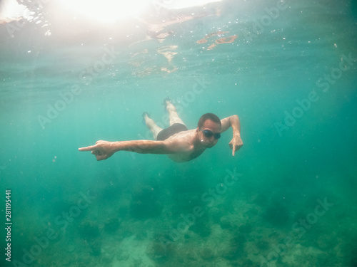 Young man swimming in blue water in the ocean