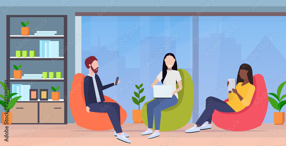 businesspeople sitting in bean bag armchair mix race colleagues team using digital gadgets social media communication concept modern office interior full length horizontal businesspeople sitting in bean bag armchair mix race colleagues team using digital gadgets social media communication concept modern office interior full length horizontal