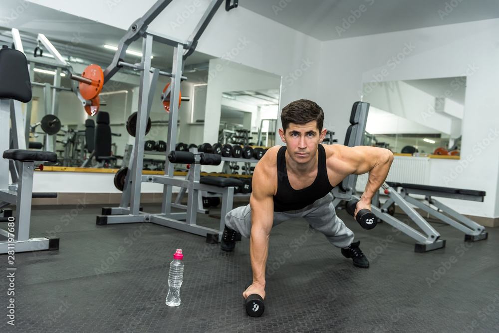man makes an exercise with dumbbell . man makes an exercise with dumbbell .