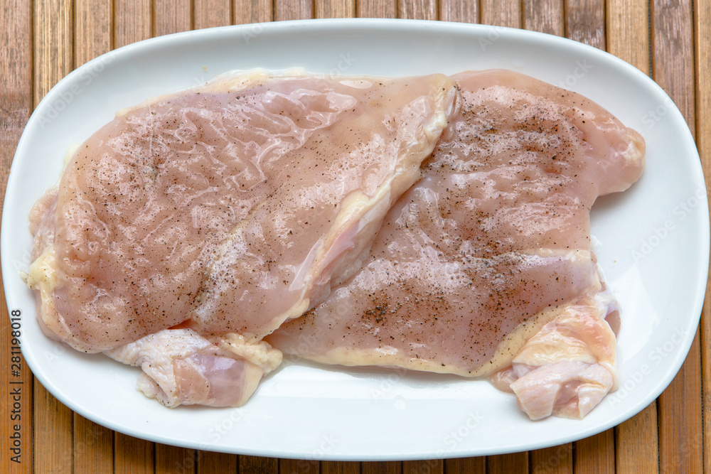 Raw chicken, semi-finished product, fillet, chipped with salt and black pepper for frying Raw chicken, semi-finished product, fillet, chipped with salt and black pepper for frying