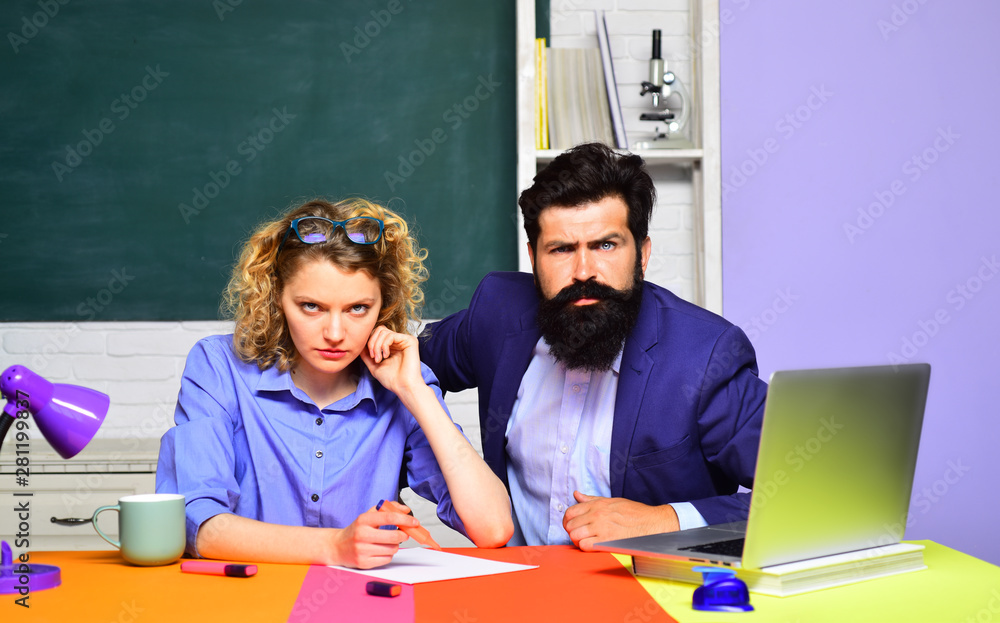 Portrait two creative students in classroom. Students and tutoring education concept. Happy female teacher with male student over green chalkboard background. Students couple studying in university. Portrait two creative students in classroom. Students and tutoring education concept. Happy female teacher with male student over green chalkboard background. Students couple studying in university.