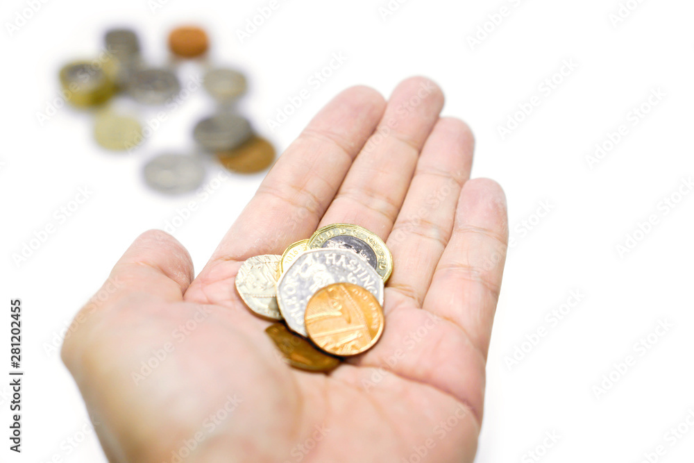 British currency coins on hand and blurry coins with isolate on white background and make with paths. British currency coins on hand and blurry coins with isolate on white background and make with paths.
