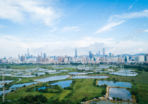 Rural green fields with fish ponds between Hong Kong and skylines of Shenzhen,China