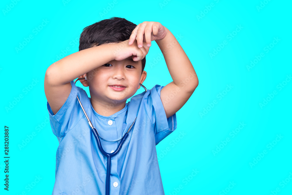 Smiling Asian kid in blue medical uniform holding stethoscope looking at camera on blue green background with copy space, healthy concept. Smiling Asian kid in blue medical uniform holding stethoscope looking at camera on blue green background with copy space, healthy concept.
