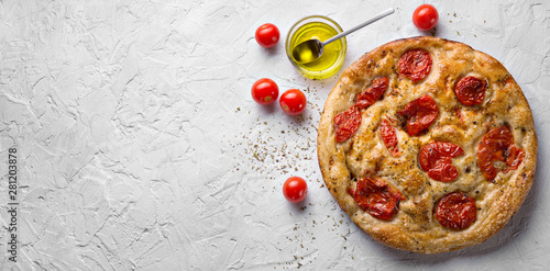 Bari-style focaccia bread, focaccia barese, focaccia with cherry tomatoes, olive oil and oregano. Top view, space for text. photo