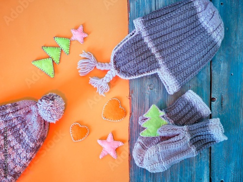 Knitted hat and mittens, Christmas decor on a bright background, the concept of home comfort, congratulations, plans for rest, top view photo