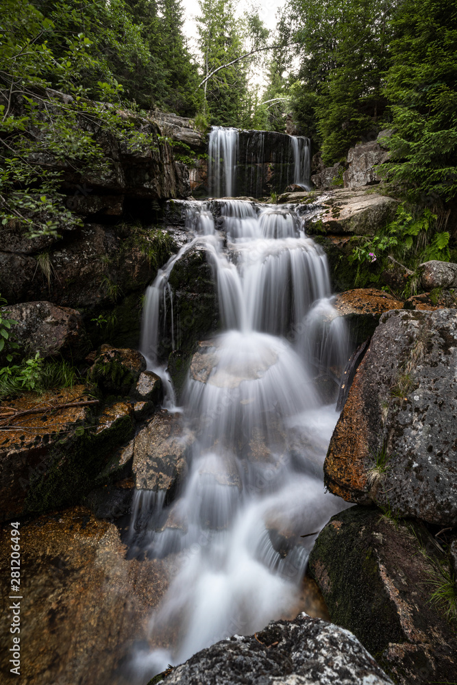 Waterfall photograph. Long exposure photo of a beautiful waterfall of Jedlova, Jizerske mountains, Czechia. Motion blurr water in a mountain creek in a deep forest. Alaska like stream with a rocks. Waterfall photograph. Long exposure photo of a beautiful waterfall of Jedlova, Jizerske mountains, Czechia. Motion blurr water in a mountain creek in a deep forest. Alaska like stream with a rocks.